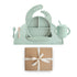The mushie Stage 2 Cambridge Blue Feeding Kit includes silicone baby utensils, a bib, divided plate, training cup with straw, two spoons, and a matching placemat—all displayed above a brown gift box tied with a white ribbon.