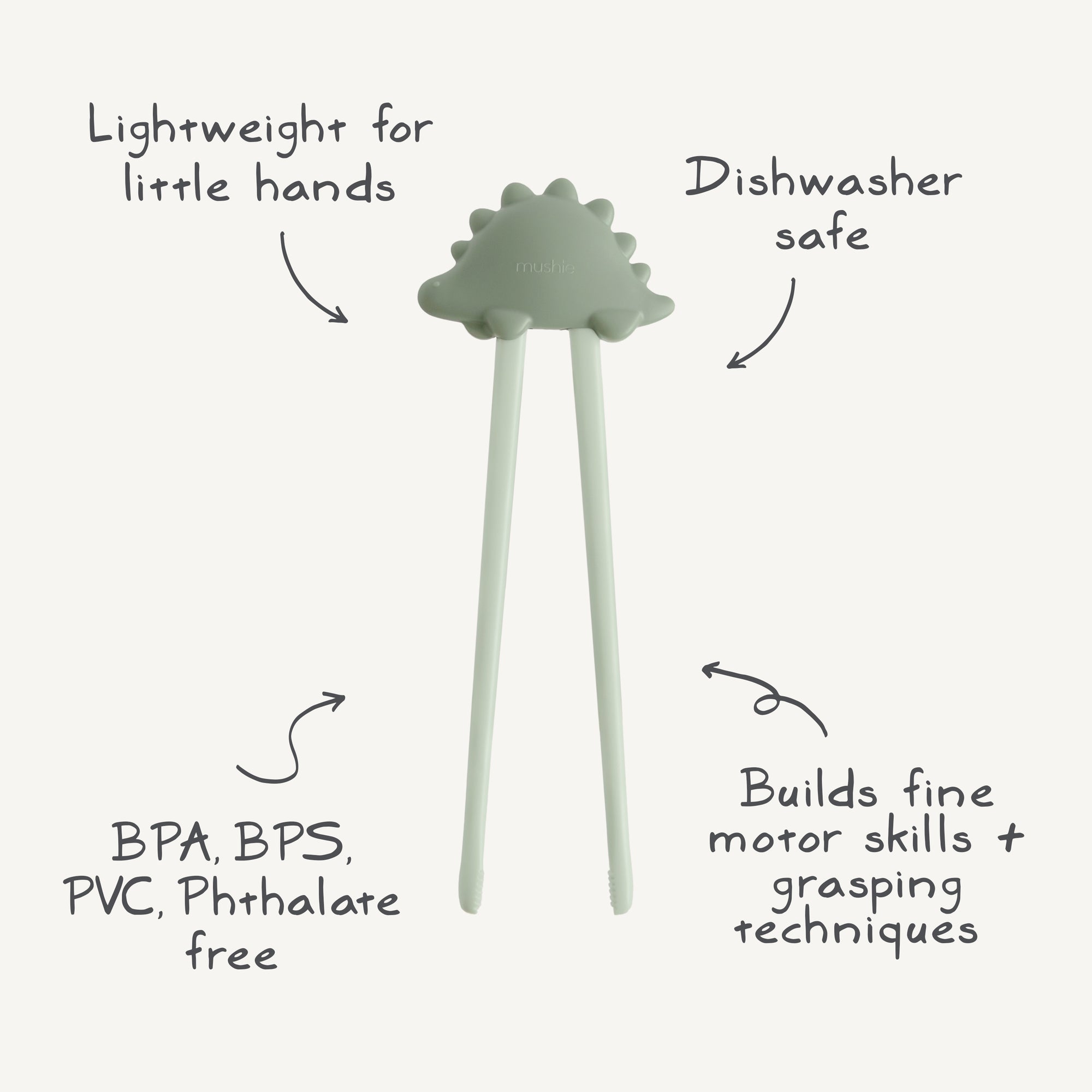 Mushie Training Chopsticks in pale green help toddlers learn self-feeding with labeled features.