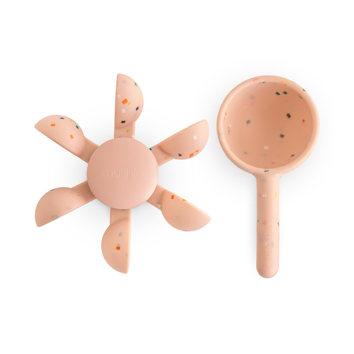 Mushie Water Wheel Bath Toy: Peach silicone flower & scoop with speckles on white background.