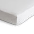 Close-up of the mushie Stretchy Crib Sheet snugly fitted over a mattress corner against a plain white background.