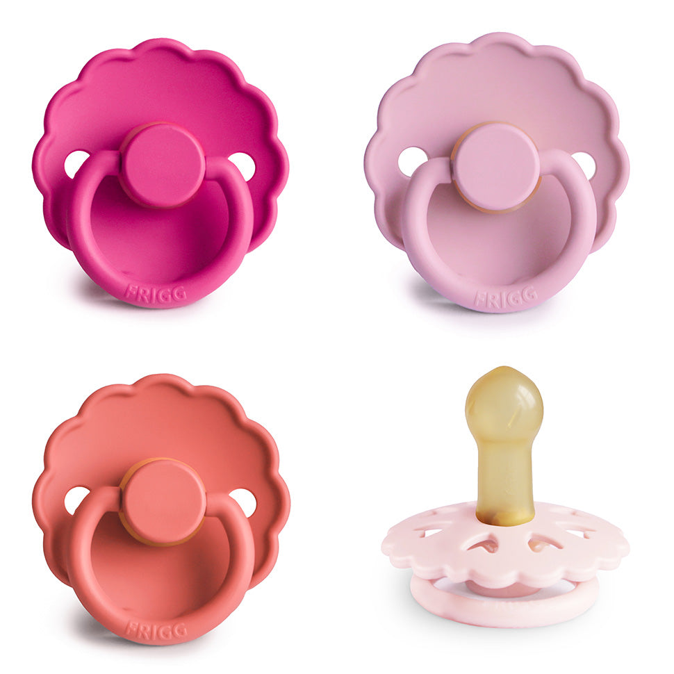 Four pink scalloped-edge FRIGG Natural Rubber Pacifiers, one with the nipple visible.