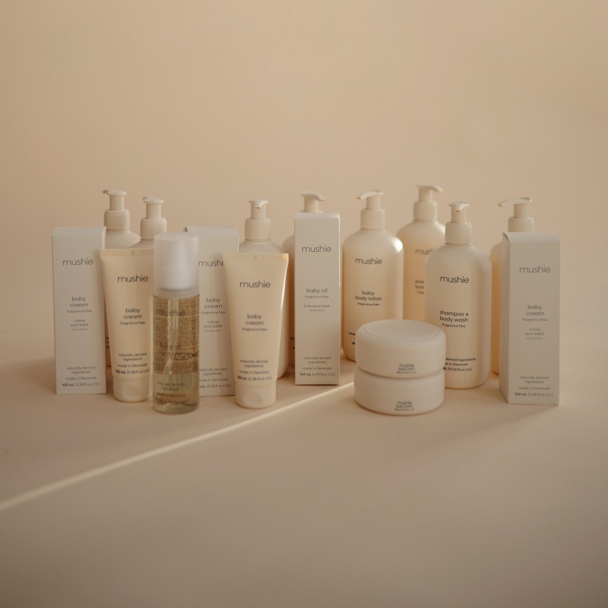 Mushie Baby Body Lotion with natural ingredients, arranged in rows with neutral tones.