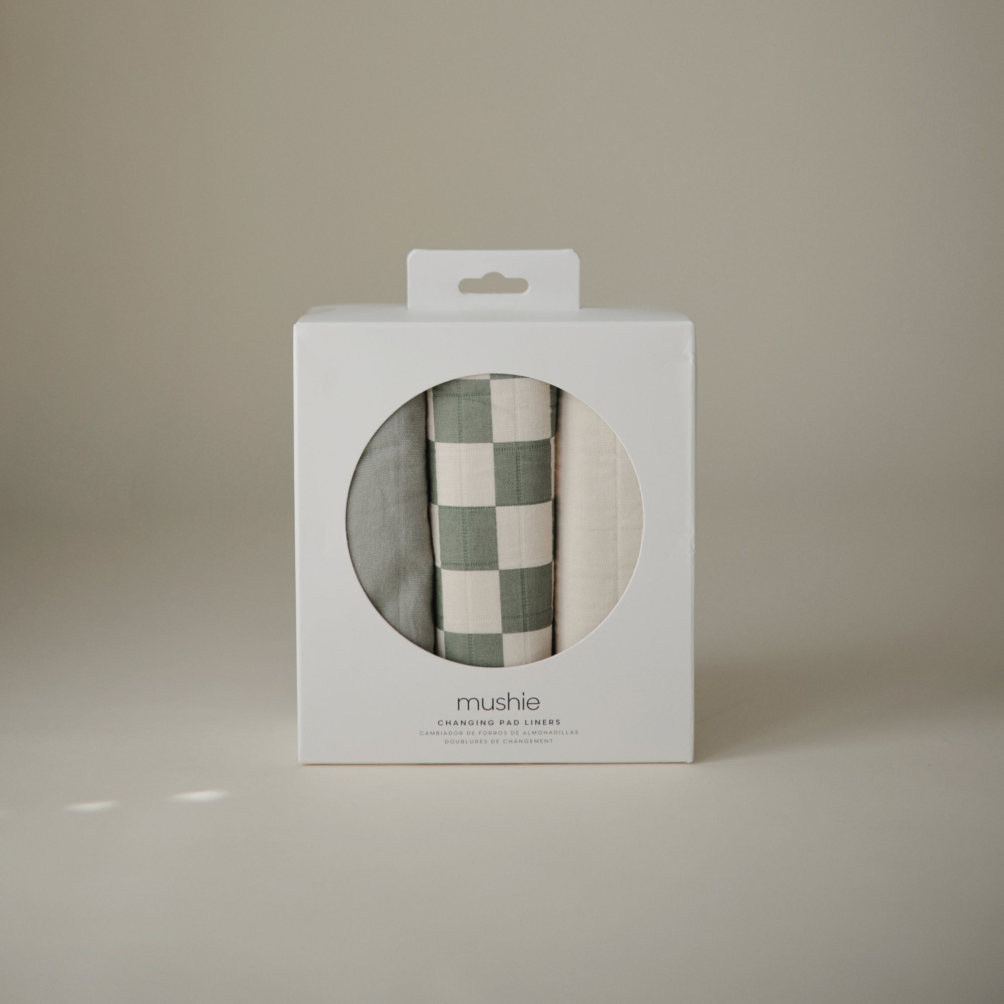Three Mushie Changing Pad Liners in a white box with a circular window on the front.