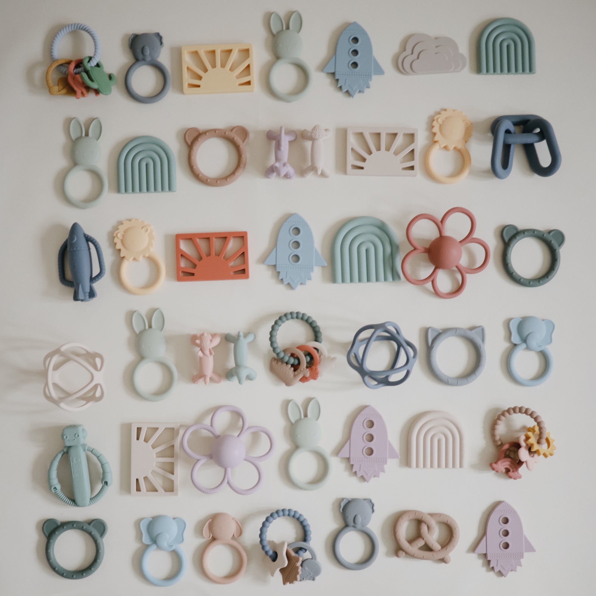 Mushie Figurine Teether toys in assorted pastels displayed on a white background.