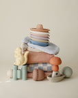 Mushie Mold Free Bath Play Set and pastel towels arranged on a light background.
