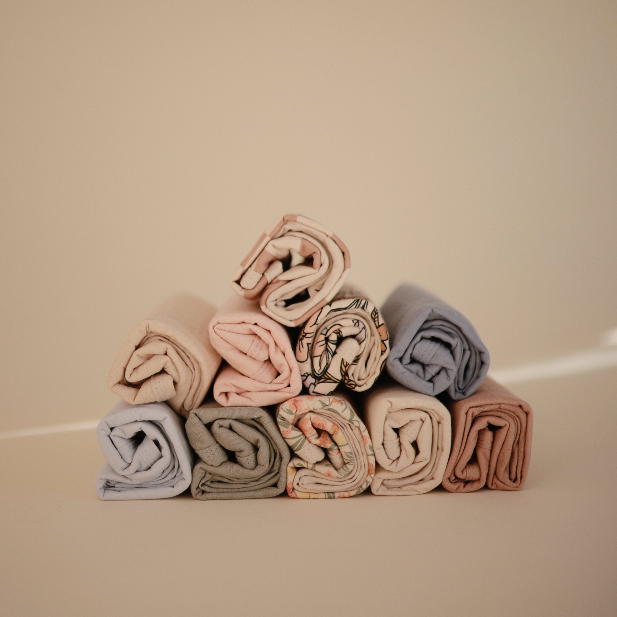 Mushie Changing Pad Liners stacked in a pyramid shape on a neutral background.