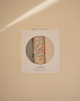 Mushie Changing Pad Liners: set of 3 muslin, one floral, shown on a beige background.