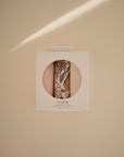 Mushie Changing Pad Liners: set of organic cotton muslin, one floral, one solid on beige.