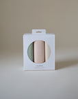 Mushie Changing Pad Liners—set of three organic cotton rolls in pastels, seen through window.