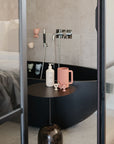 Modern black bathtub with mushie Baby Shampoo & Body Wash beside a bed in a cozy room.