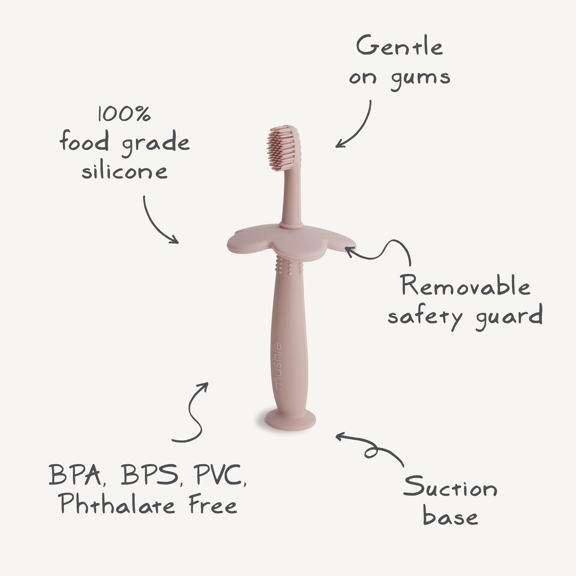 The mushie Flower Training Toothbrush is a pink, 100% food-grade silicone baby toothbrush with soft bristles, a removable safety guard, suction base, and is free from BPA, BPS, PVC, and phthalates. Gentle on gums.