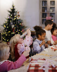 Kids decorate cookies as timeless toys while mushie Kaleidoscopes spark playful exploration nearby.