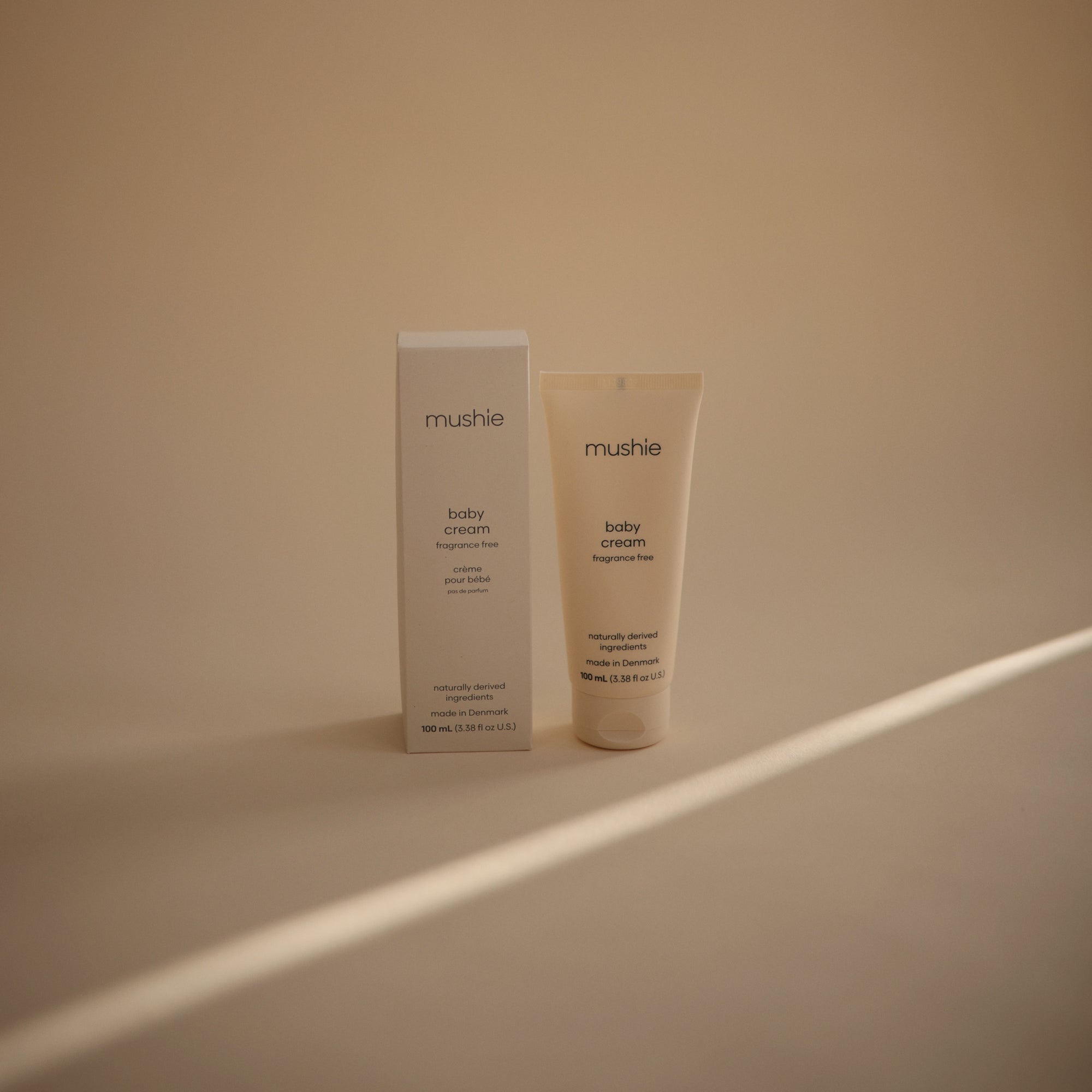 Mushie Baby Cream tube and box on beige background, ideal for soothing dry skin.