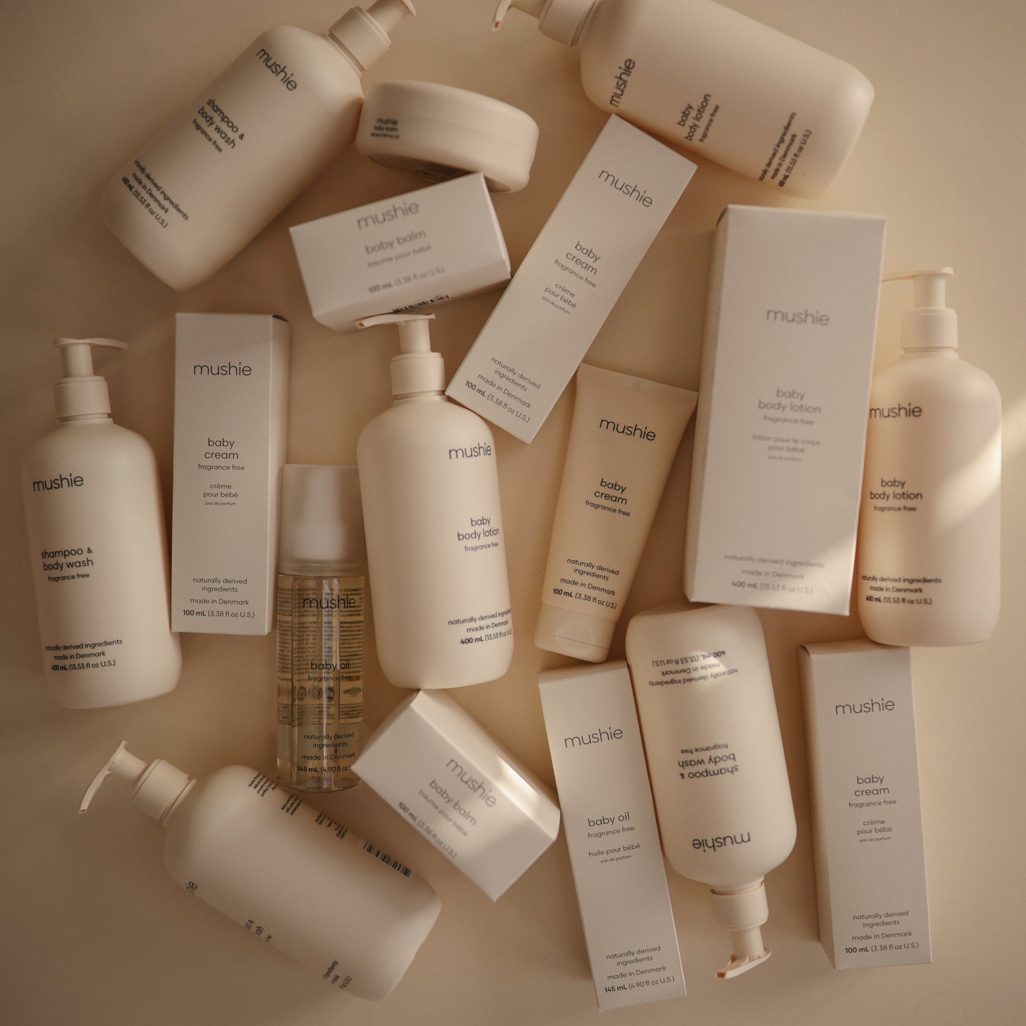 Several mushie Baby Body Lotion bottles and boxes displayed on a neutral background.