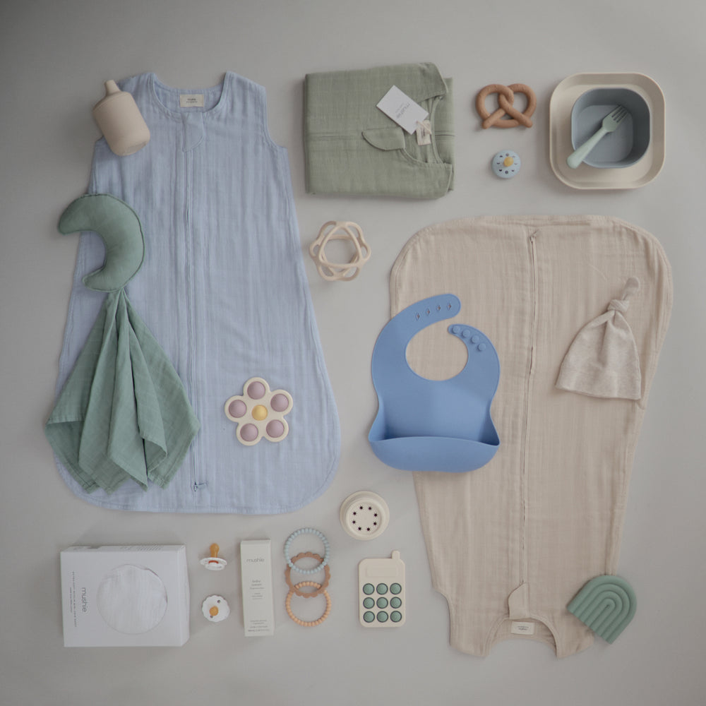 Lifestyle image of Sleep Bags in a flat lay with dinnerware and toys. 