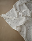 Lifestyle image of Organic Cotton Swaddle in Leaves