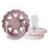 The FRIGG Andersen Fairytale Silicone Pacifier 2-Pack features two pink pacifiers with heart-shaped cutouts, one upright and one flat. Made in Denmark from soft silicone, they combine comfort and style for your baby.