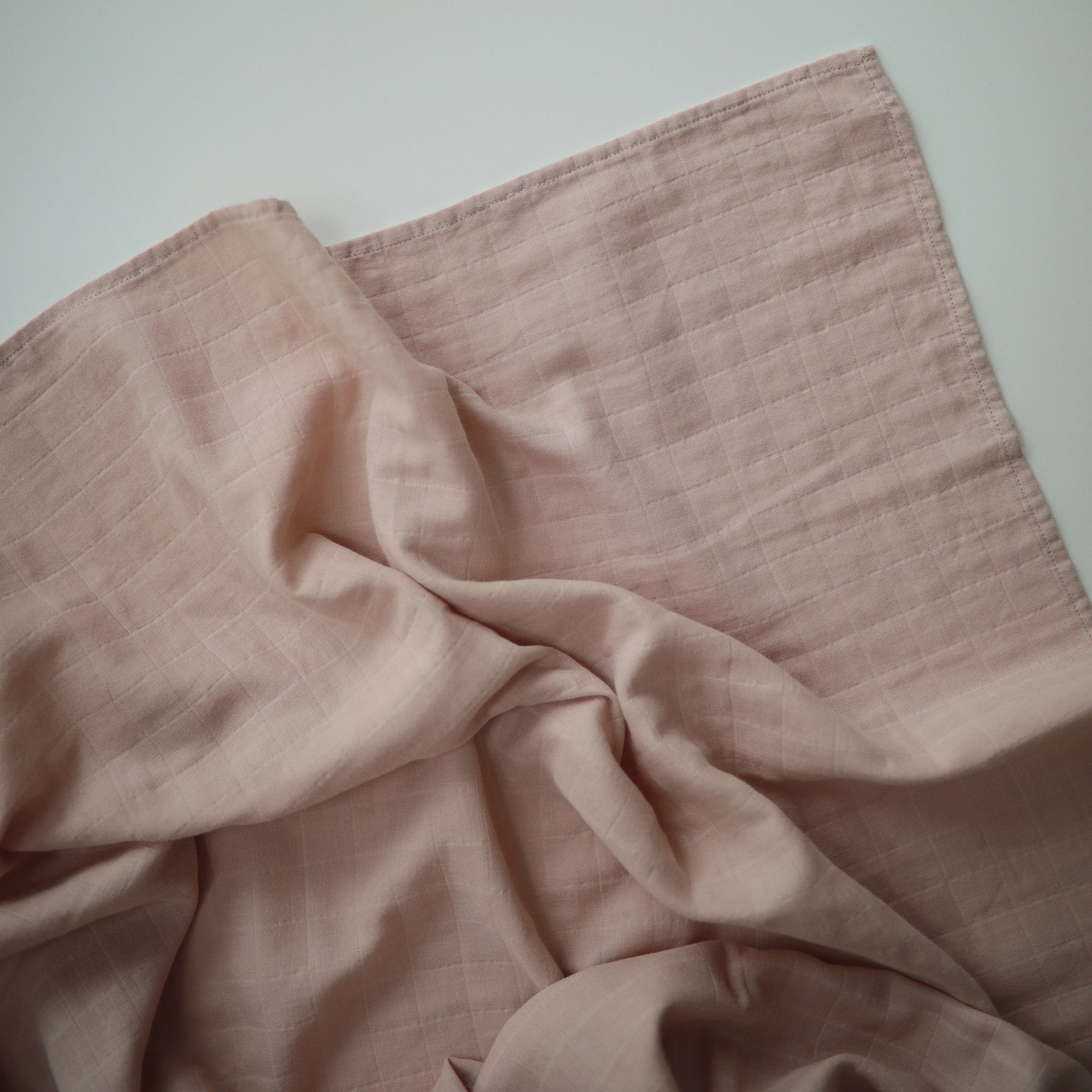 Lifestyle image of Organic Cotton Swaddle in Blush