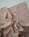 Lifestyle image of Organic Cotton Swaddle in Blush