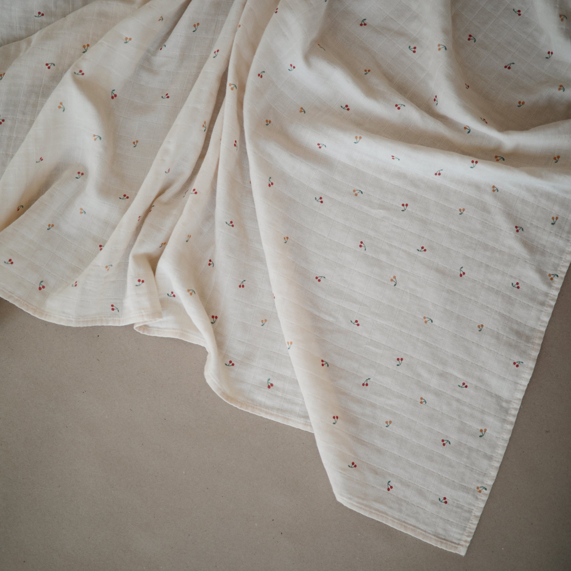 Lifestyle image of Organic Cotton Swaddle in Cherries