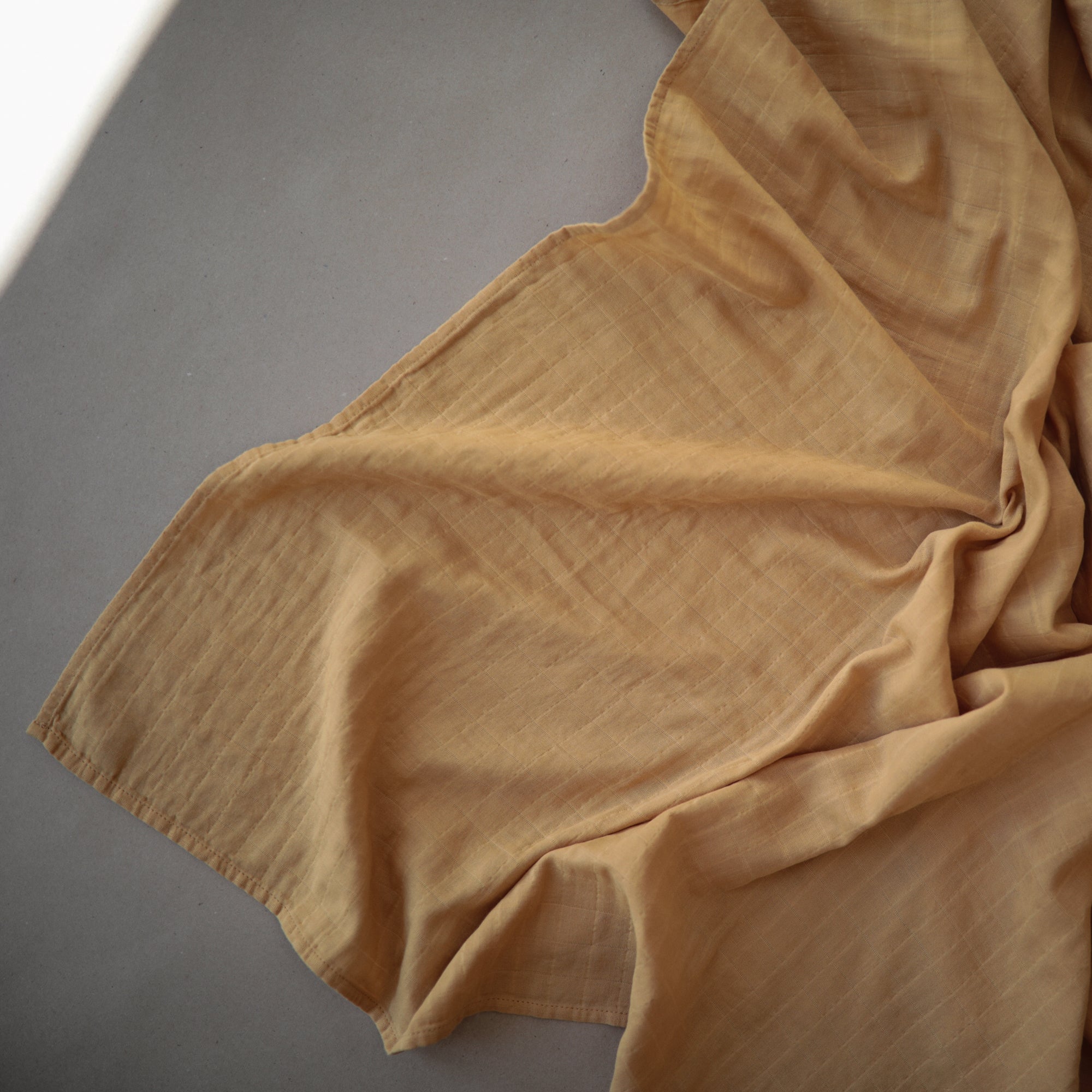 Lifestyle image of Organic Cotton Swaddle in Fall Yellow