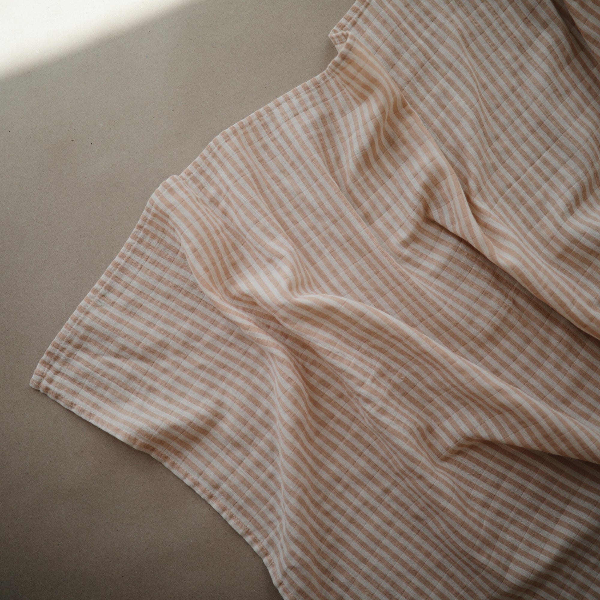 Lifestyle image of Organic Cotton Swaddle in Natural Stripe