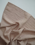 Lifestyle image of Organic Cotton Swaddle in Pale Taupe