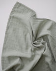 Lifestyle image of Organic Cotton Swaddle in Sage