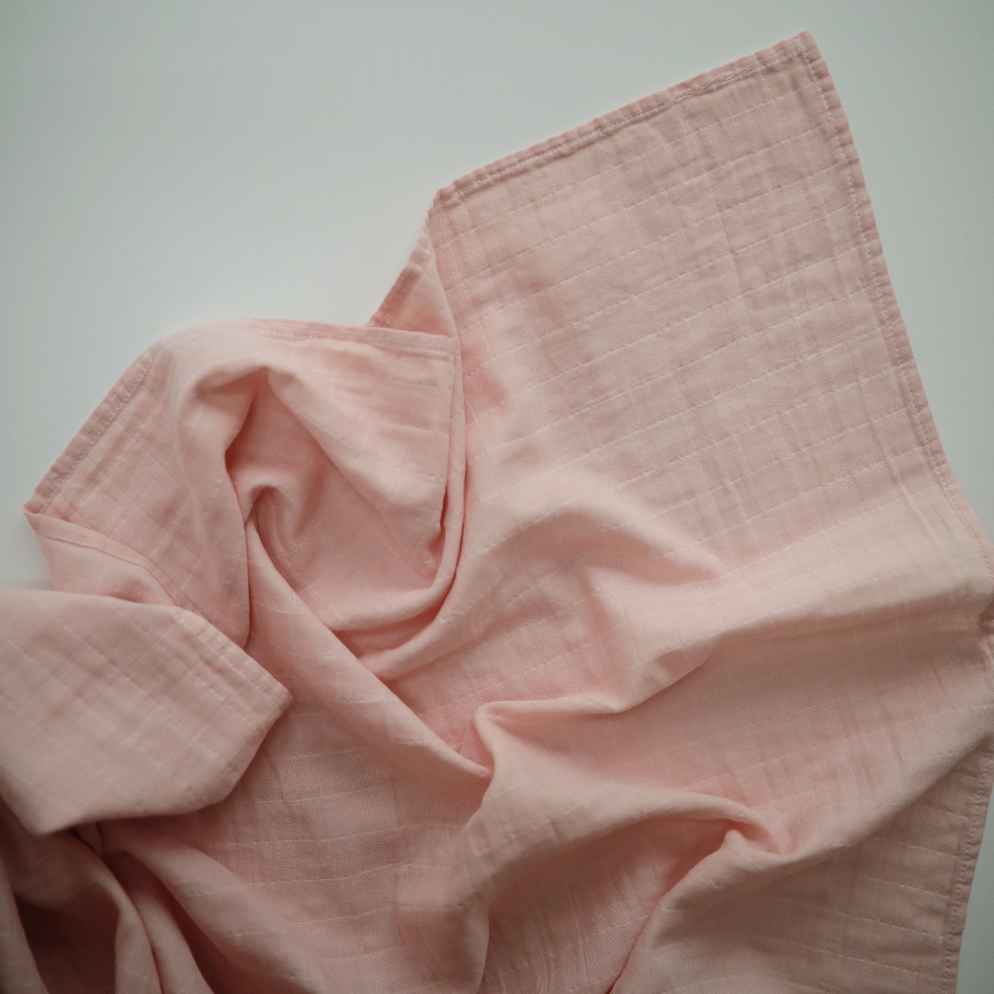 Lifestyle image of Organic Cotton Swaddle in Rose Vanilla