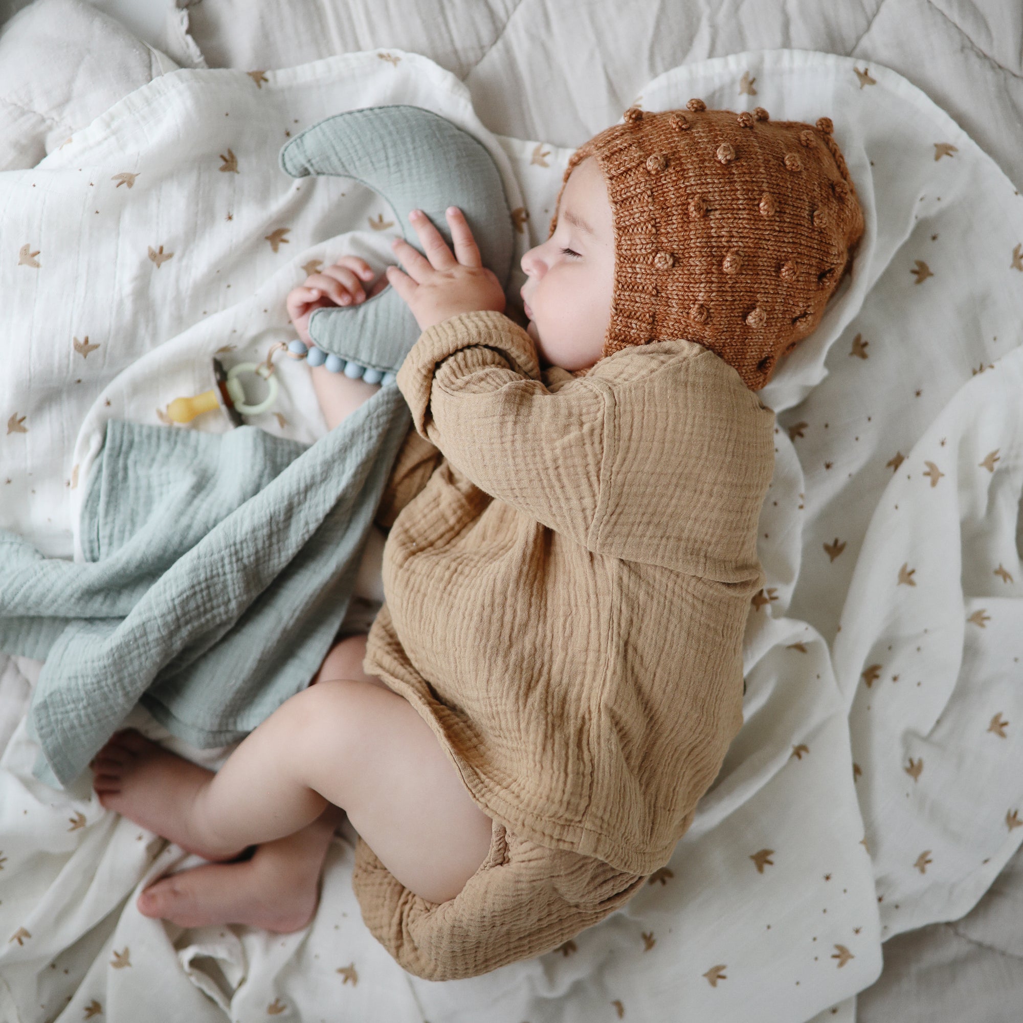 Lifestyle image of a baby swaddled in organic cotton swaddle in Sparrow 