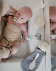 Lifestyle image of a bath mitt resting next to a baby.