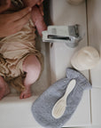 Lifestyle image of a bath mitt resting next to a baby.