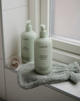 Lifestyle image of a bath mitt and Green Lemon Baby Skincare