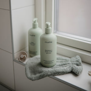 Lifestyle image of a bath mitt and Green Lemon Baby Skincare